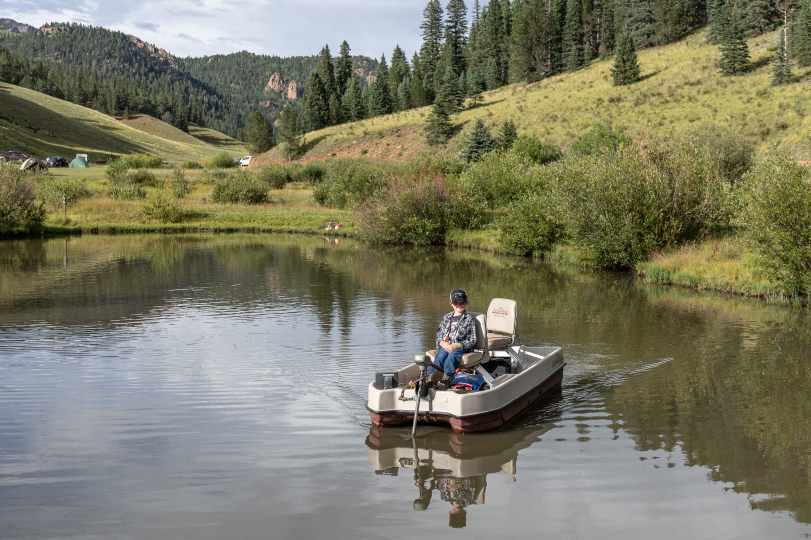 An angler fishing from a paddle boat on the lodge pond