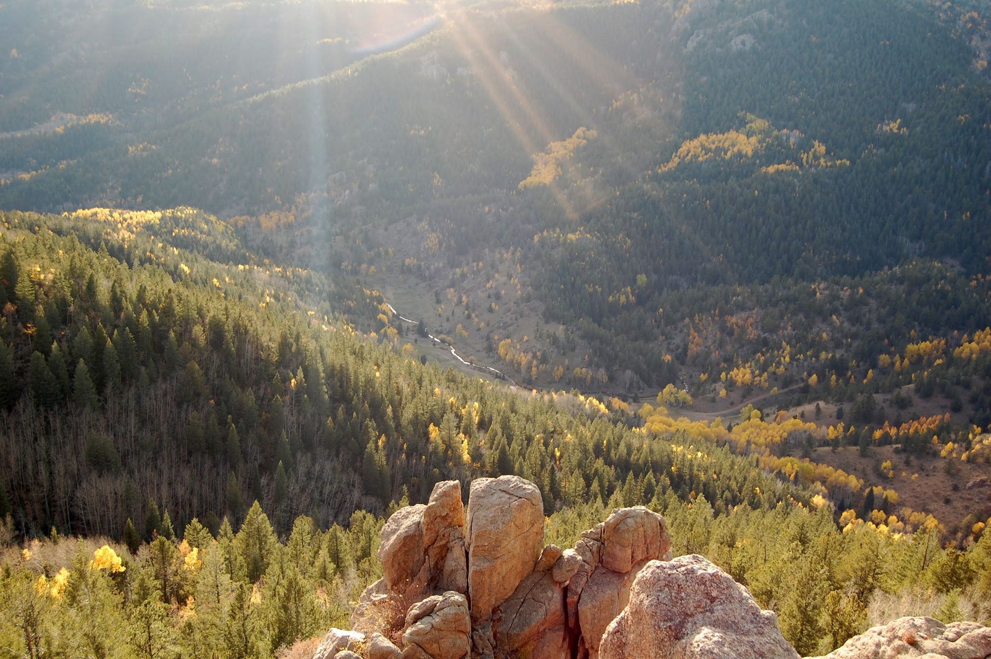 Sun over the canyon and the fall aspens, seen from the rocks above the ranch
