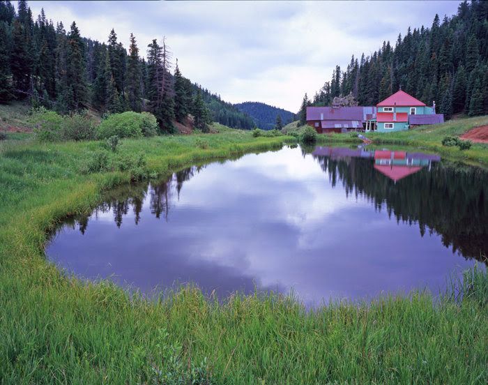 The ranch lodge reflected in the pond below it