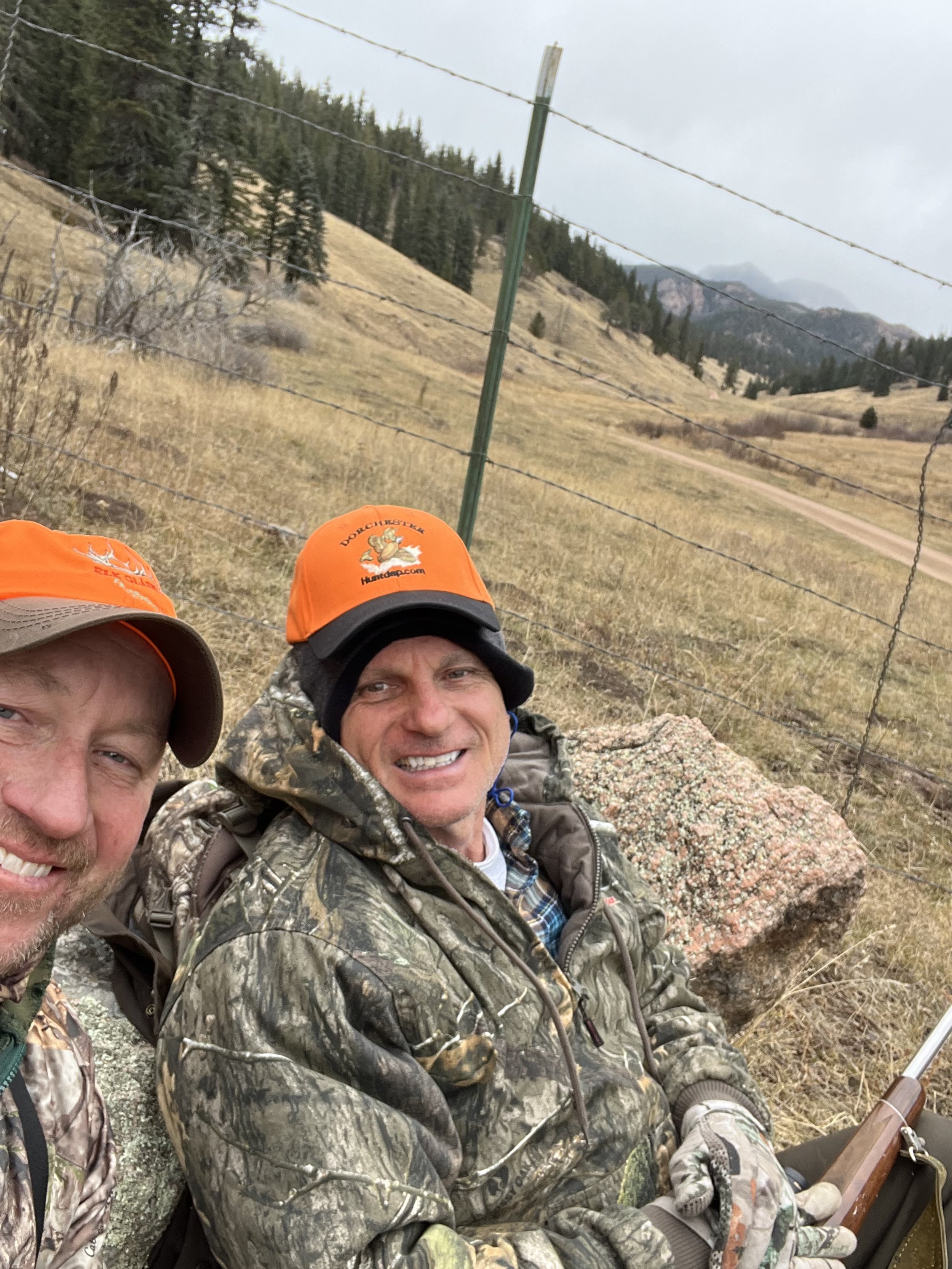 Two hunters in blaze orange on a fence-line ridge at Elk Glade