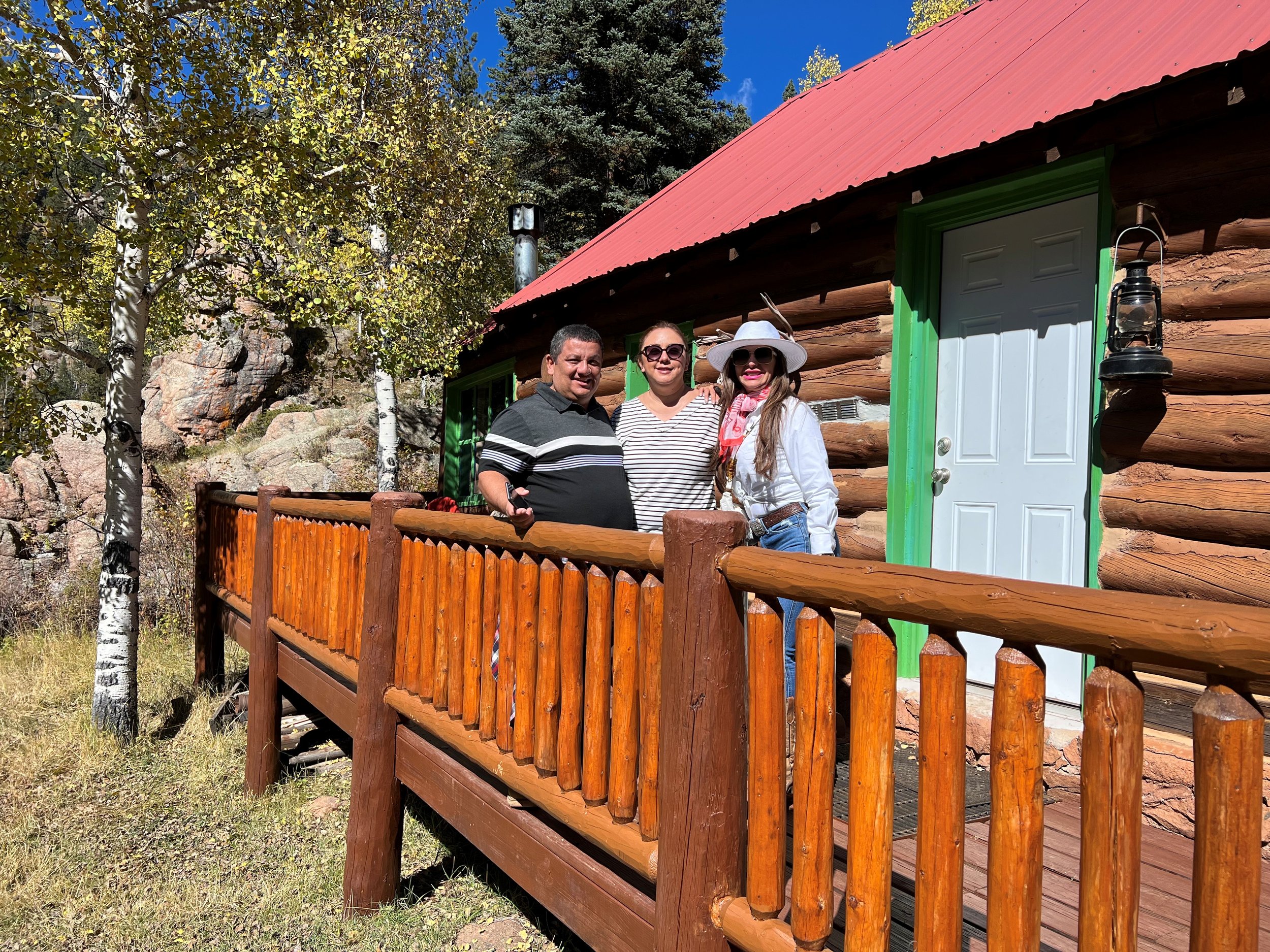 Guests on the log porch of a ranch cabin
